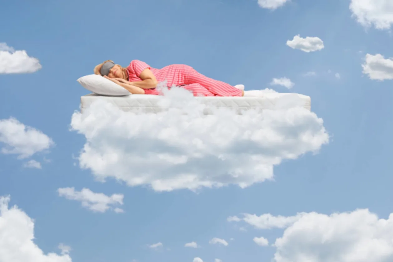 mature woman in pyjamas on mattress on cloud